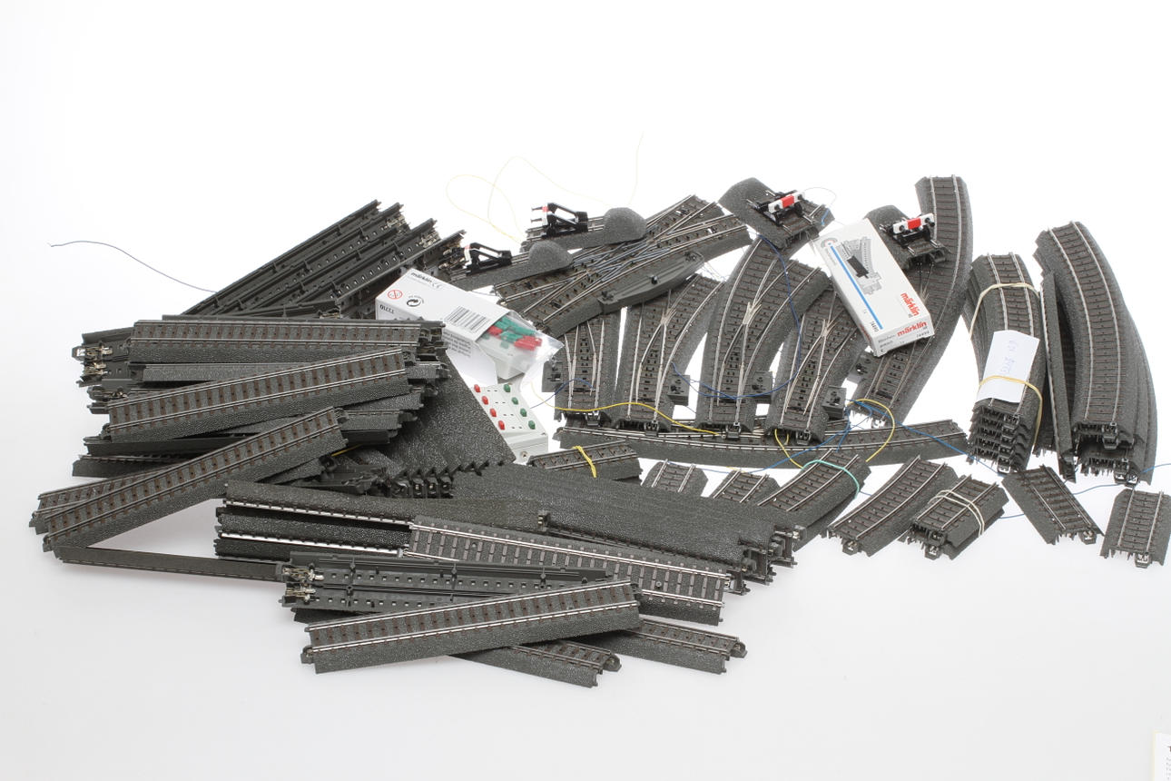 MODELLTÅG MÄRKLIN C-RÄLS. Cirka 50 raka, 14 böjda, 11 passbitar, 4 stoppbockar, 3 elektriska kurvväxlar, 1 elektrisk korsväxel och 3 elektriska växlar. Ställpultar.