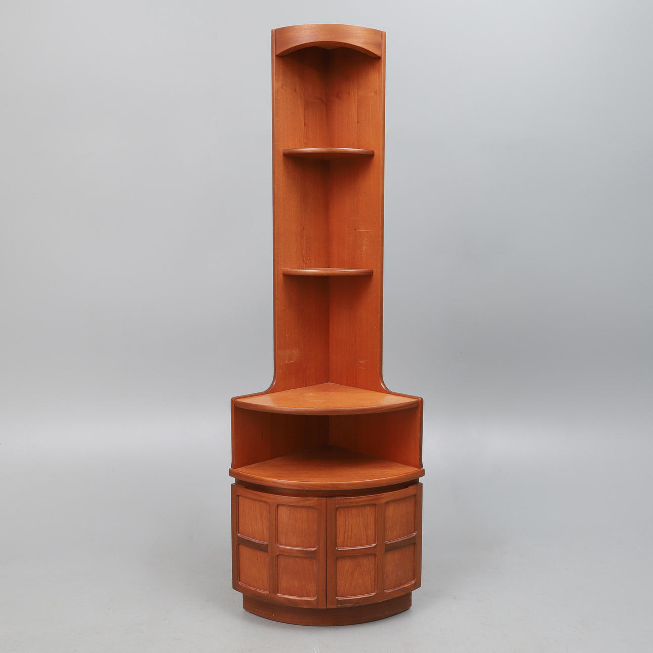 EIN NATHAN QUADRATISCHER TEAKBODEN-STEHENDER ECKSCHRANK MIT BÜGELFRONT.