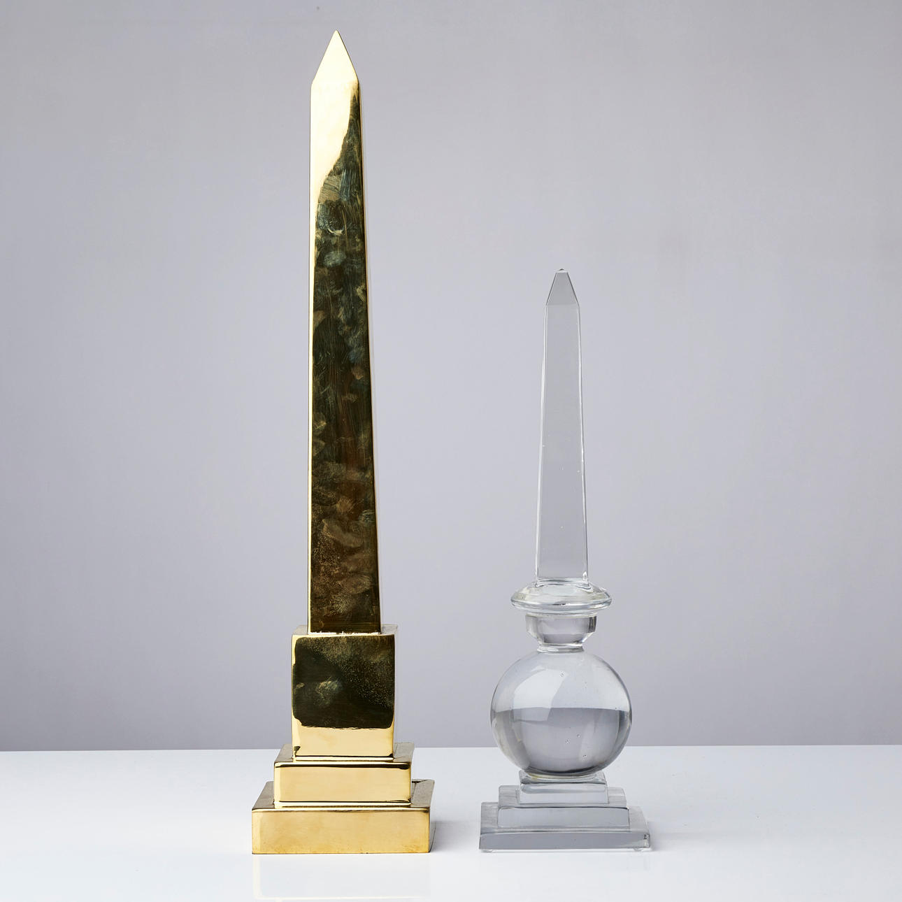 OBELISKER, 2 st, i glas respektive gulmetall. Övrigt - Övrigt - Auctionet