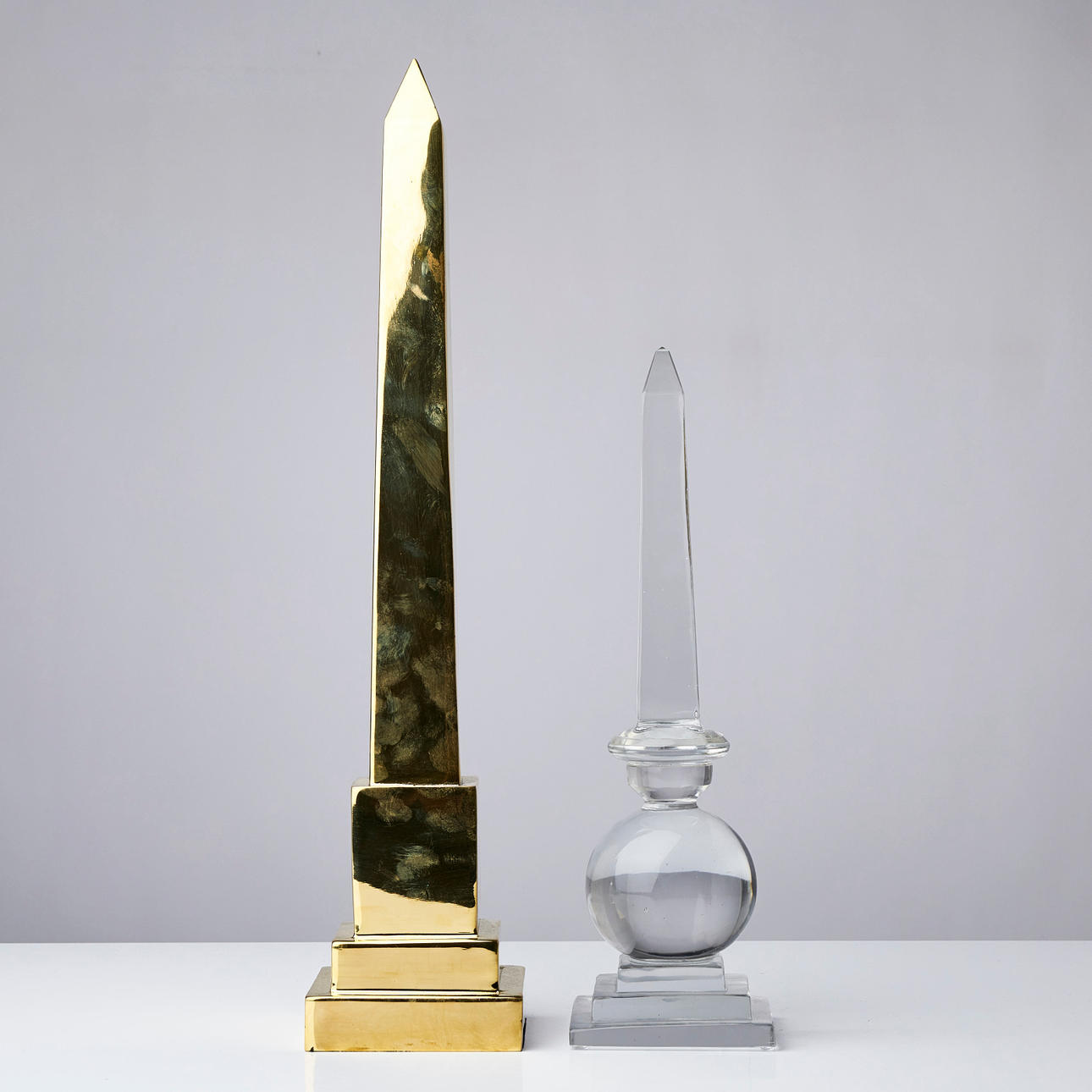 OBELISKER, 2 st, i glas respektive gulmetall. Övrigt - Övrigt - Auctionet