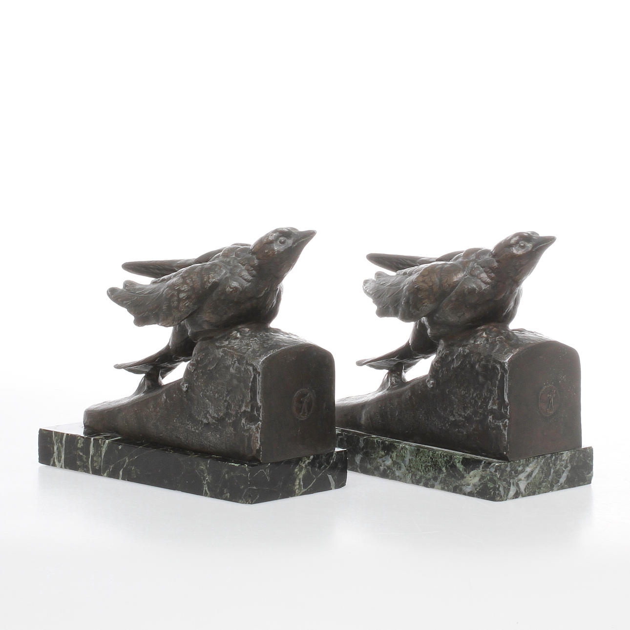 GEORGES VAN DE VOORDE. 1 par bokstöd, patinerad vitmetall på stensockel, signerade.