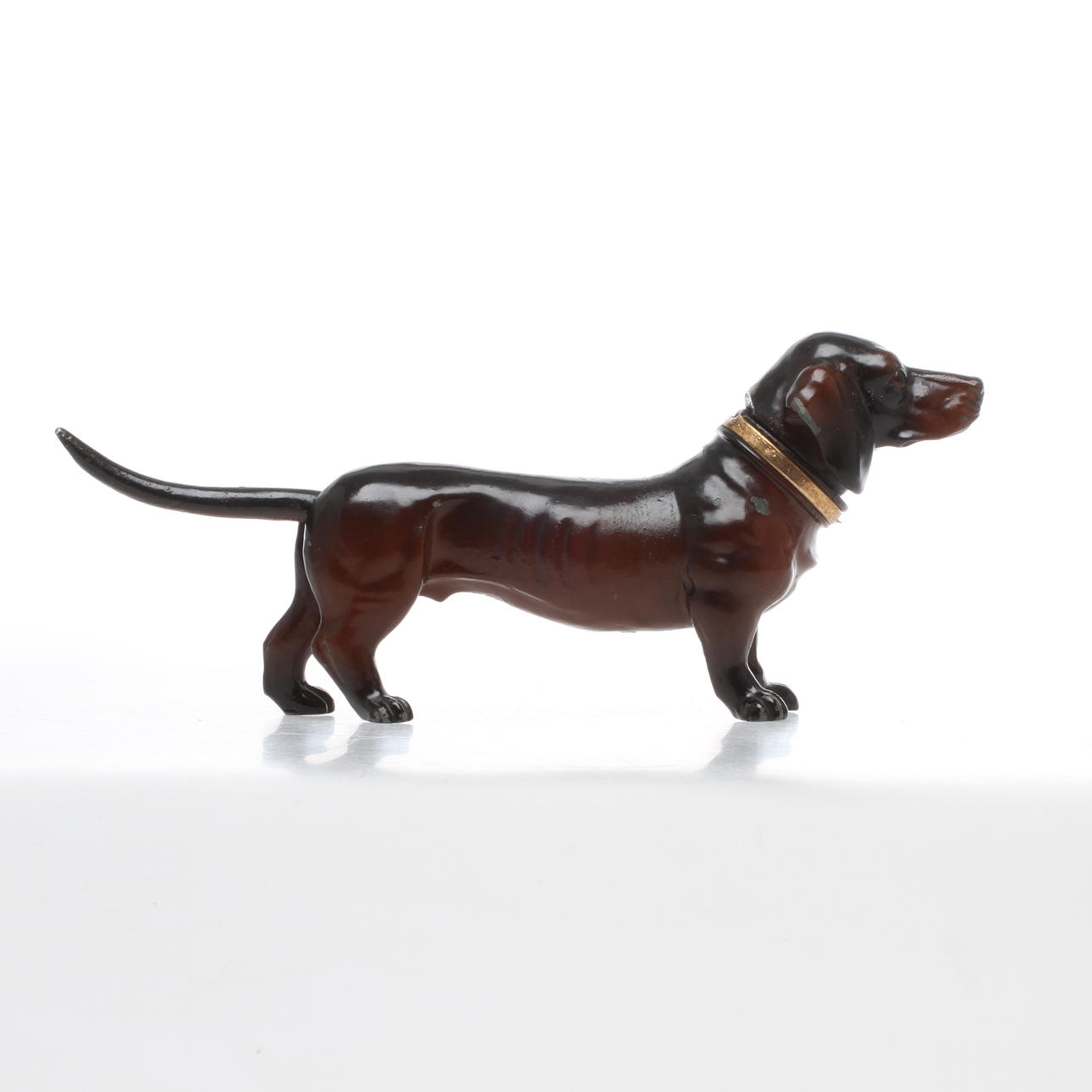 TÄNDARE, bemålad metall, bordsmodell, i form av tax, 1900-talets första hälft.