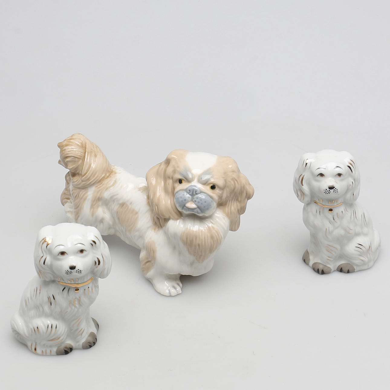 FIGURINER i porslin. 3 st. pekinges och parhundar.