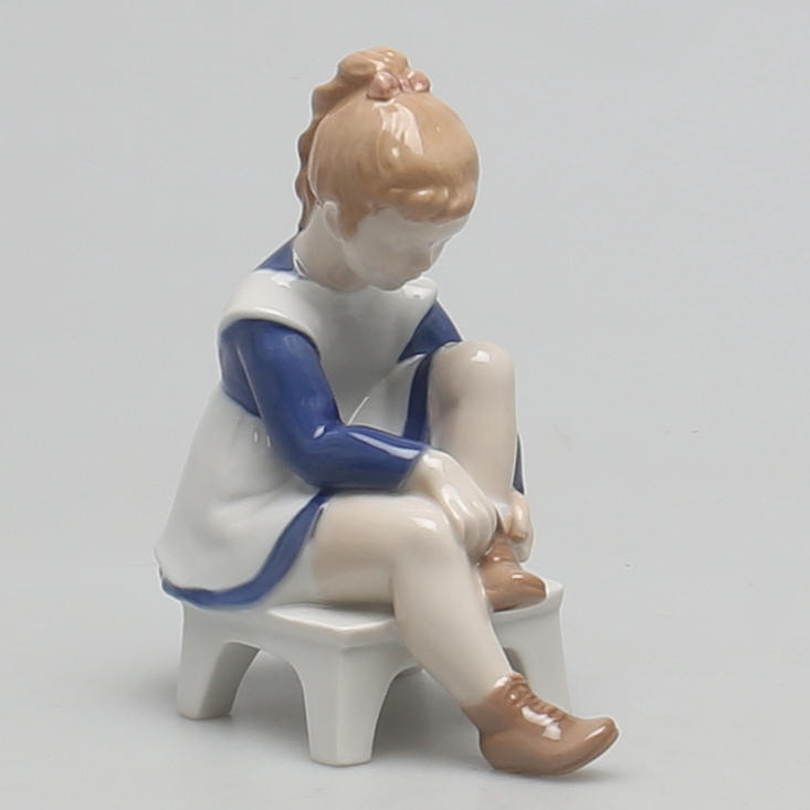 FIGURIN i porslin. Flicka snörar sin sko. Bing&Gröndahl.