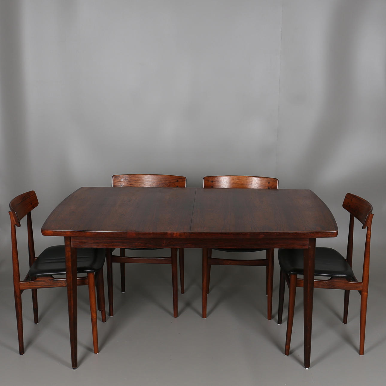 MATSALSMÖBLEMANG i jakaranda. Bord och stolar med klädsel i svart skinn. 1960-tal.