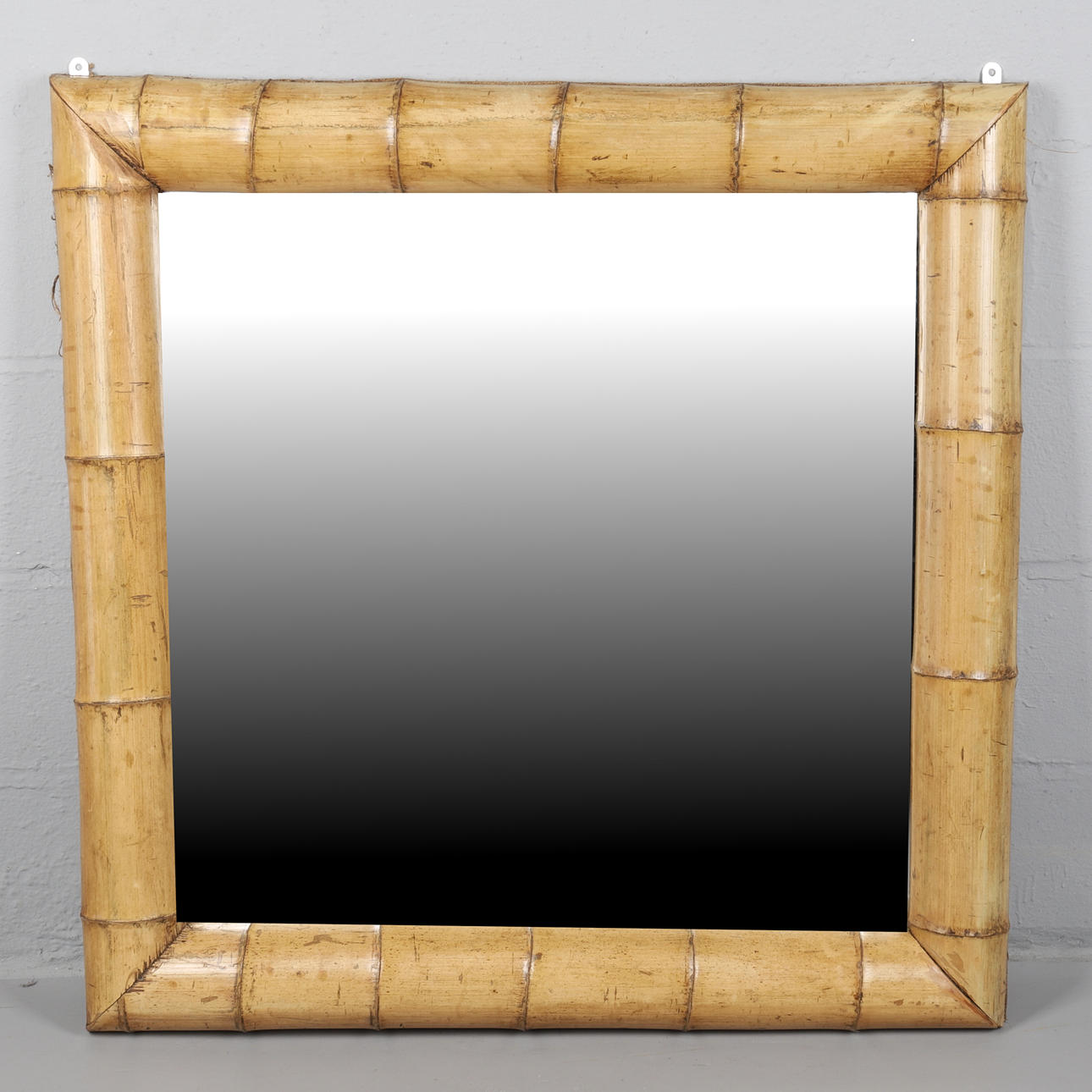 UN MODERNO ESPEJO DE PARED CON MARCO DE BAMBÚ.