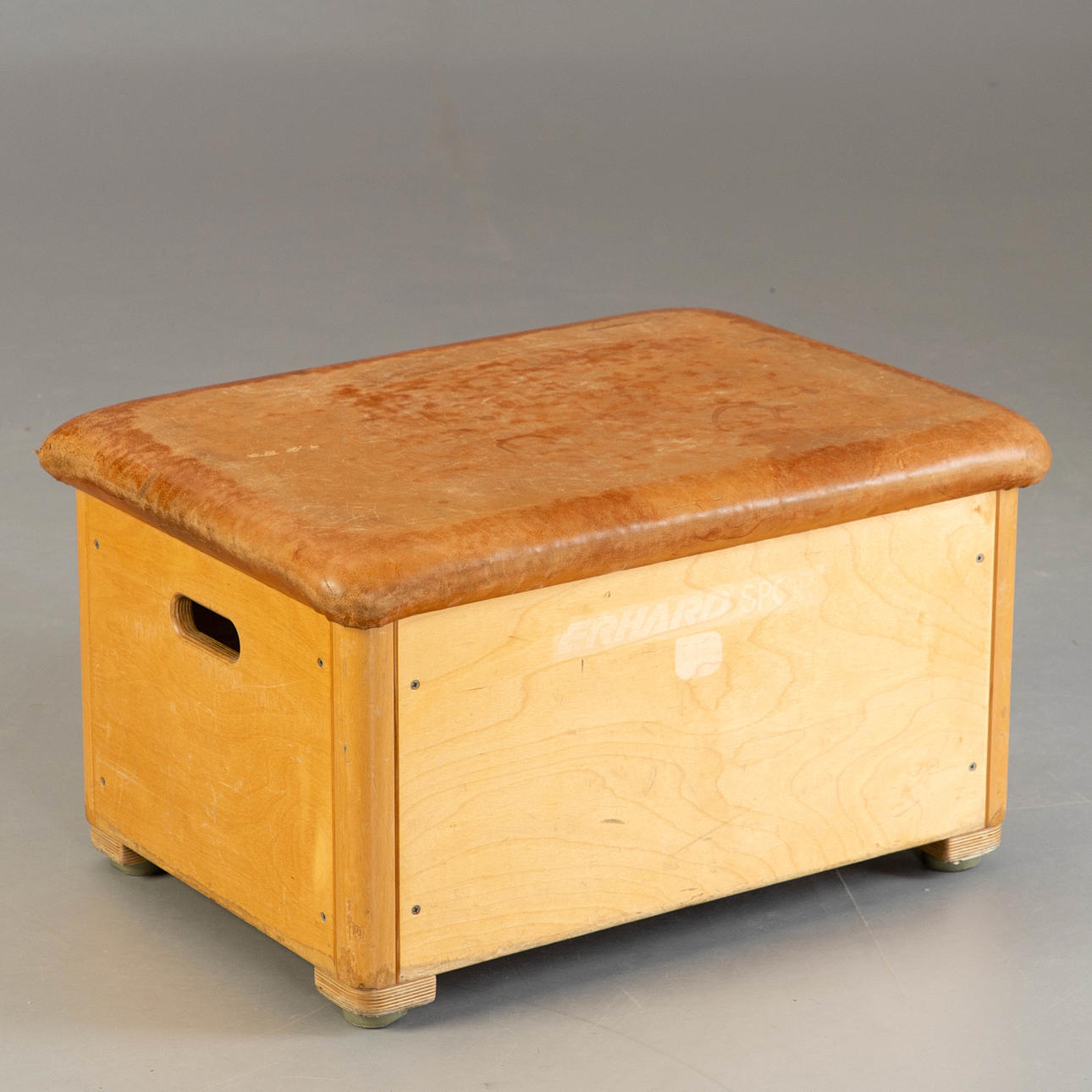 Liten hoppbox/ottoman med läderöverdrag.