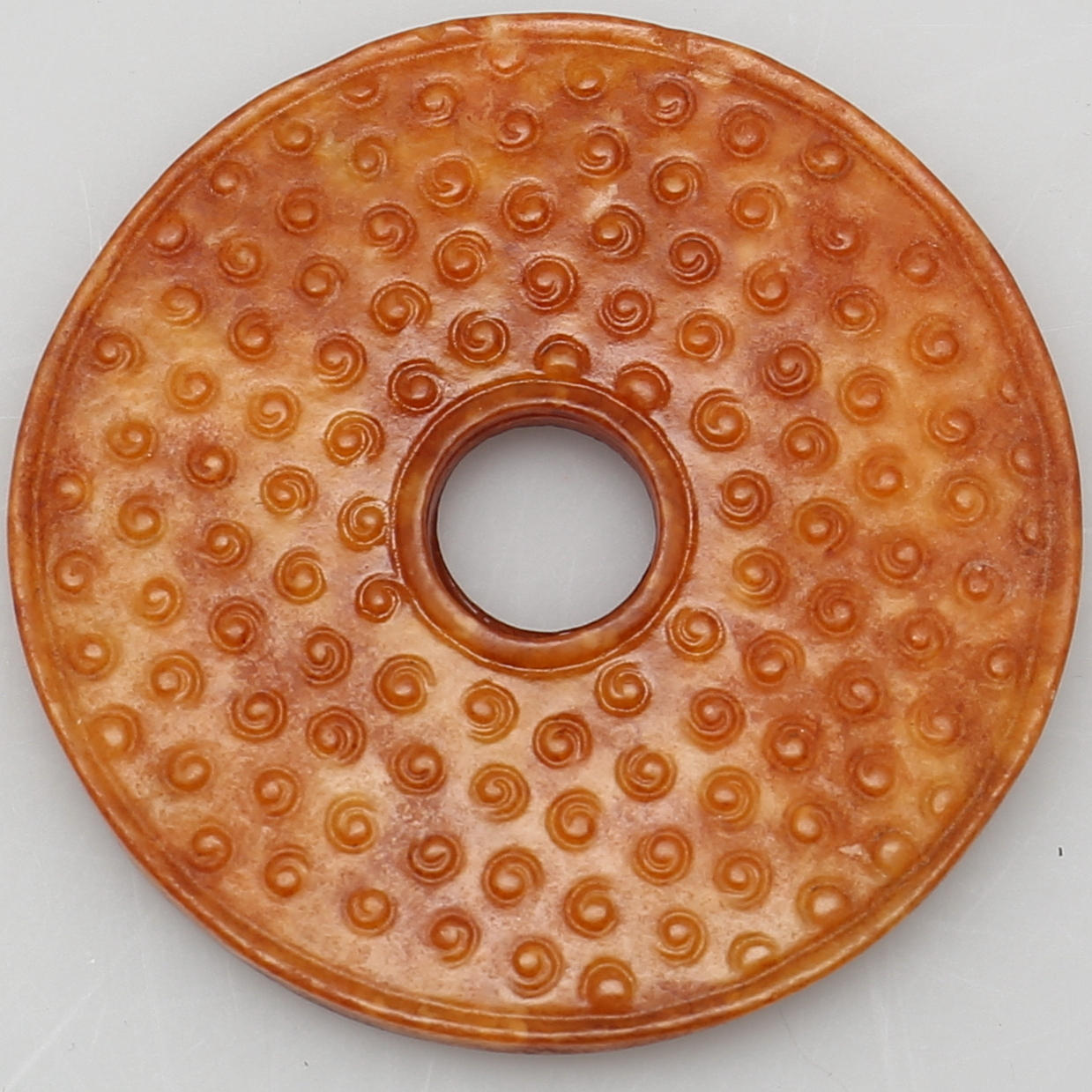 AMULETT. Stenarbete. Jade ?. Dekor av cirklar.