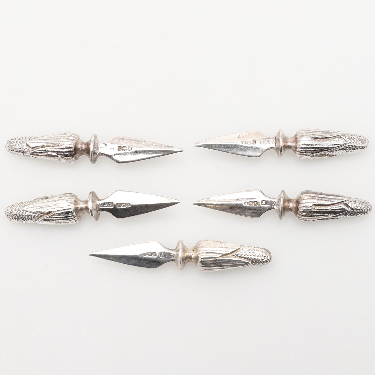 FIVE CAST SILVER CORN ON THE COB SPIKES.