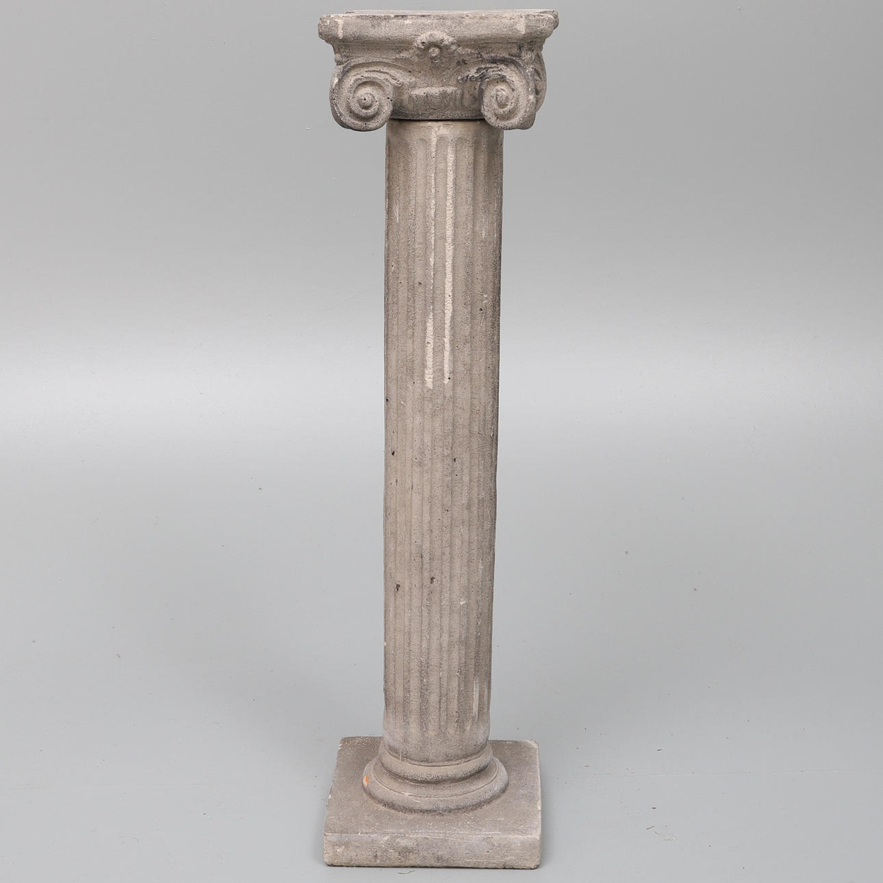 EN VITTRAD REPRODUKTION FÖRGJUTEN JONISK KOLONN.