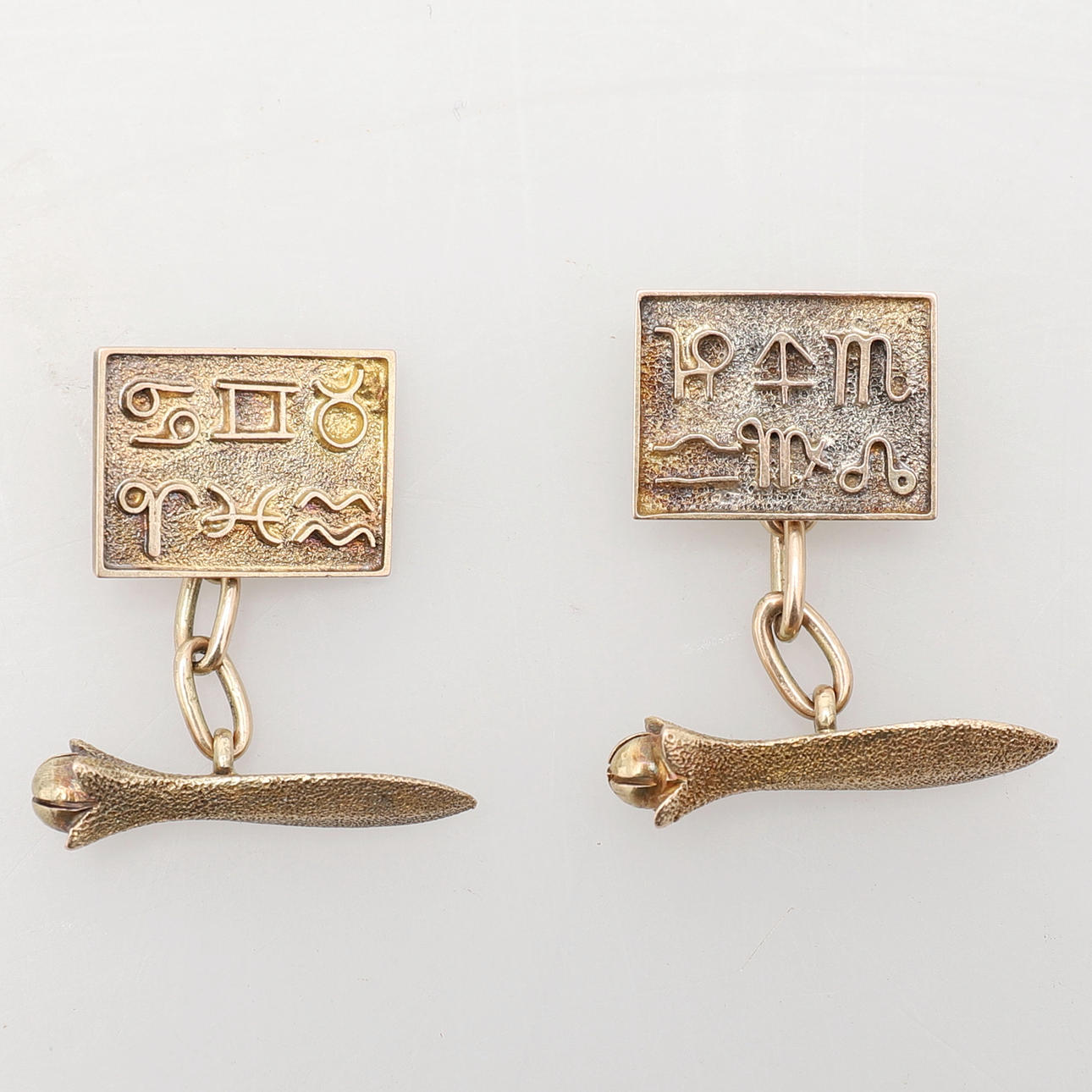 EIN PAAR GOLDENE TIERKREISSYMBOL MANSCHETTENKNÖPFE.