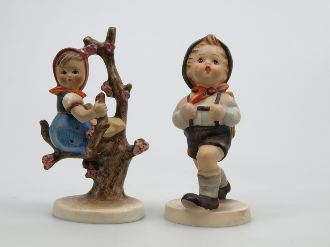 FIGURINER, porslin, 2 stycken, Pojke med skolväska och Flicka i träd. Hummel.
