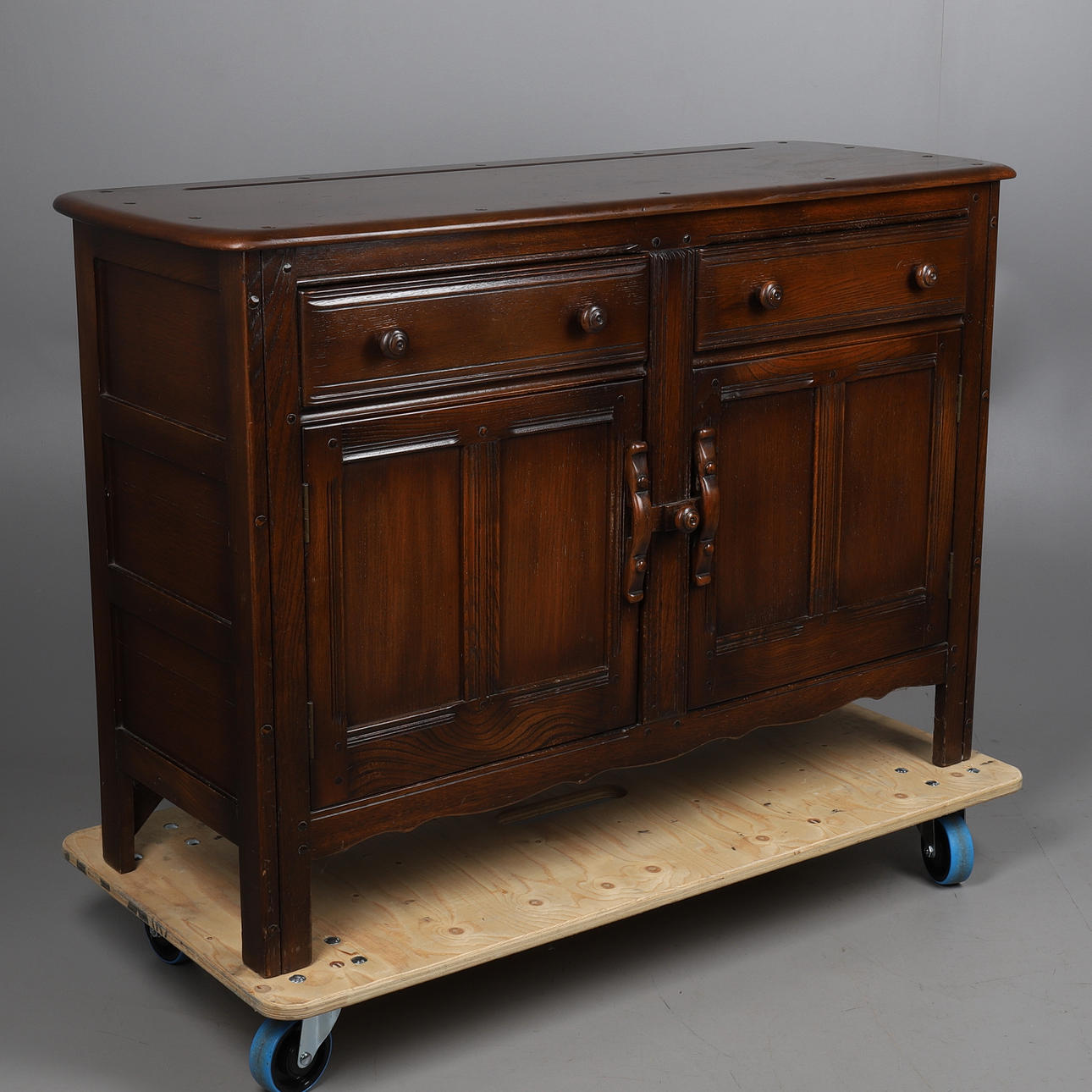 AN ERCOL OLD COLONIAL SIDEBOARD.