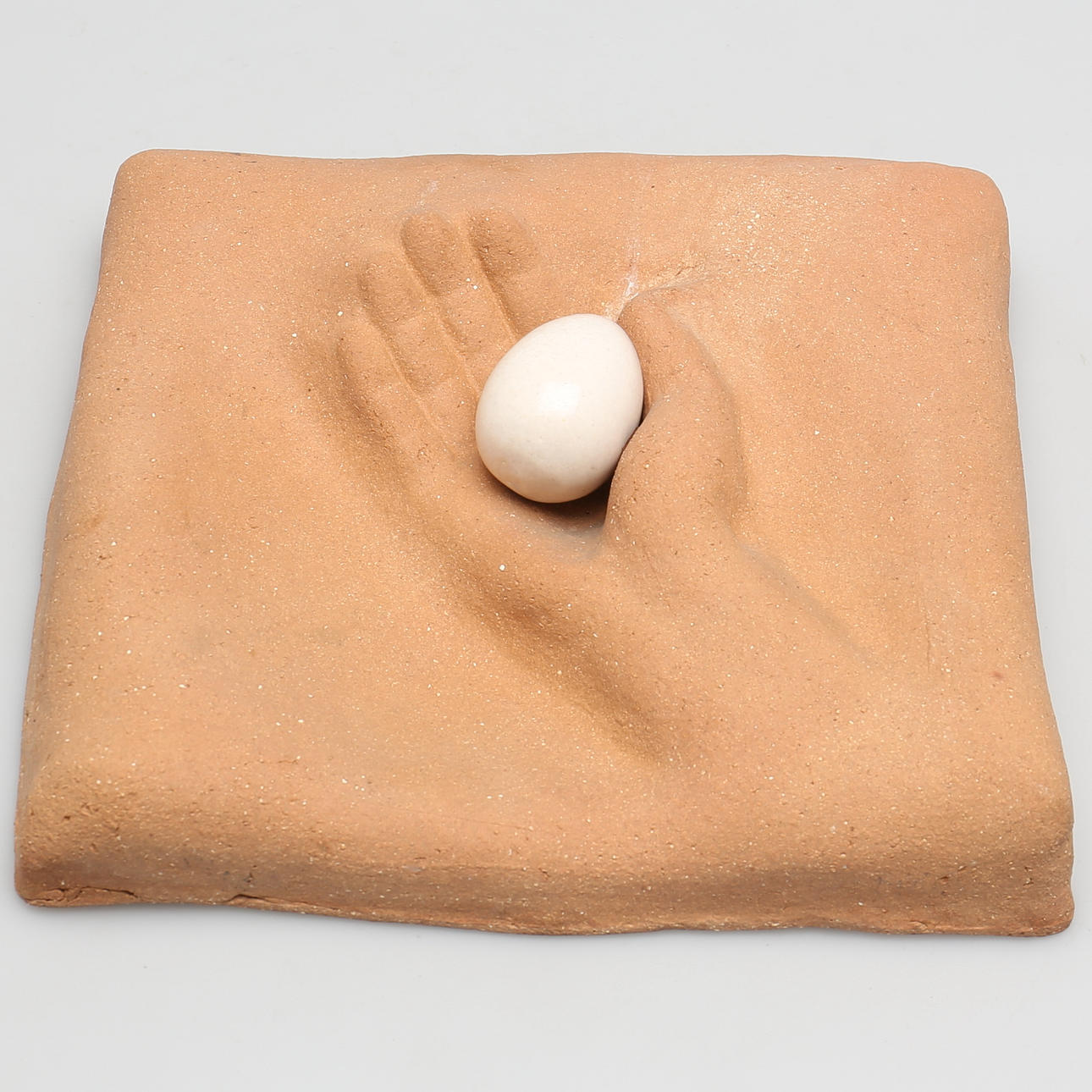 OIDENTIFIERAD KONSTNÄR. Väggrelief. Stengods. "Hand m Ägg".