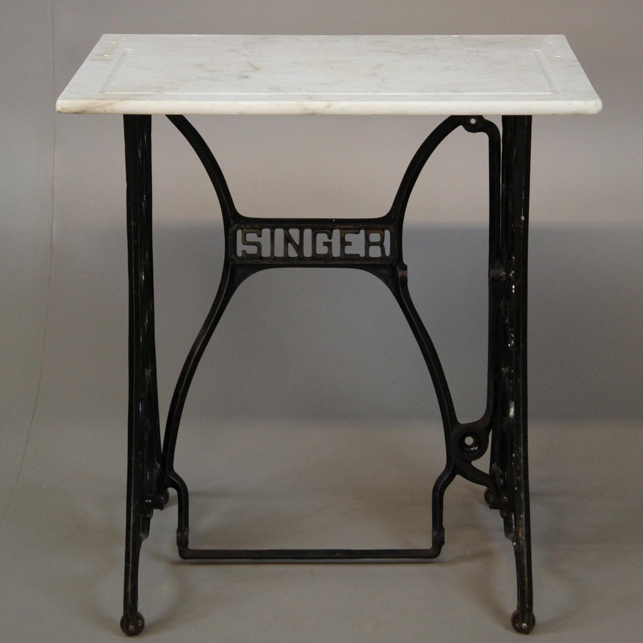TABLE with sewing machine base and marble top.