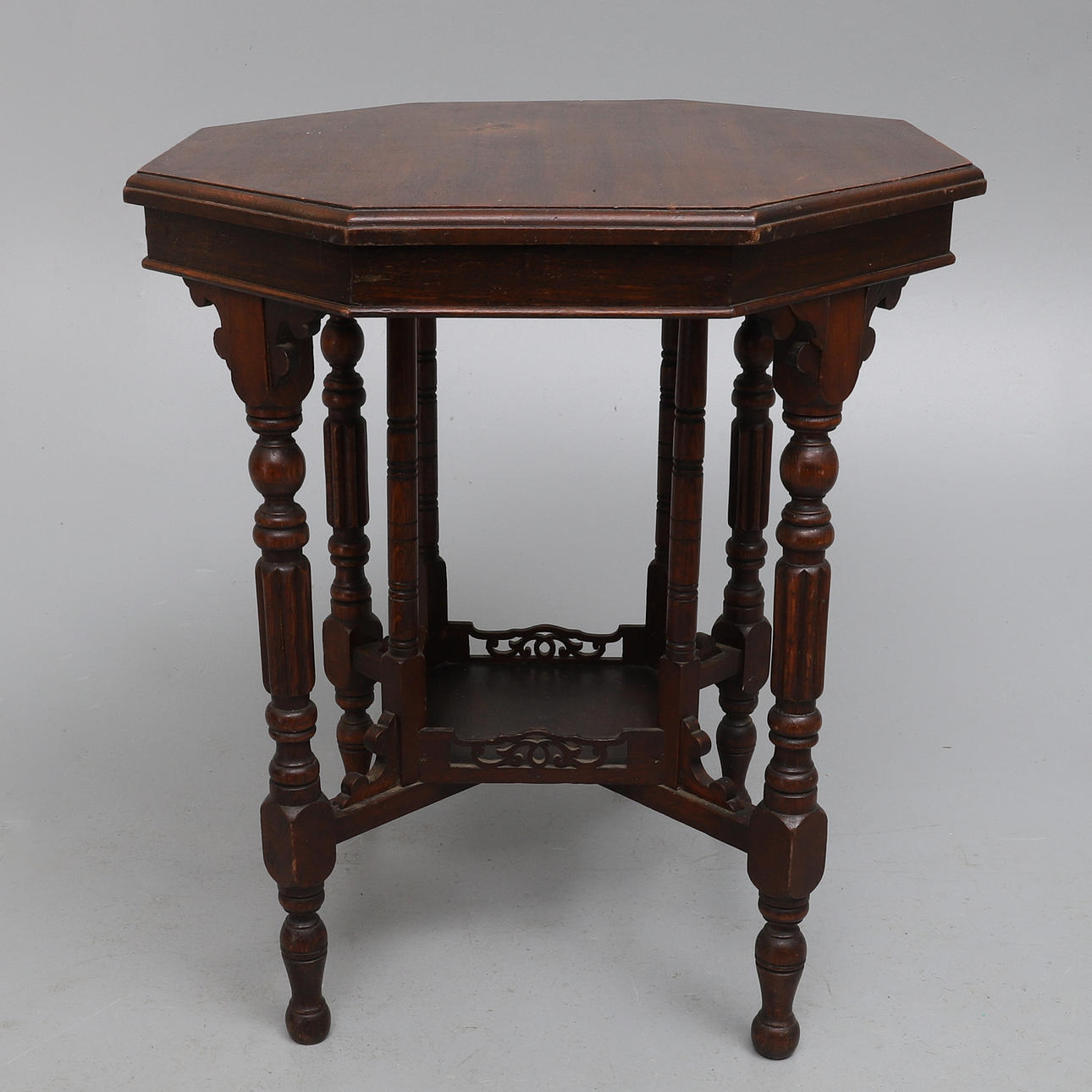 AN EDWARDIAN OCTAGONAL WALNUT TWO-TIER WINDOW TABLE.