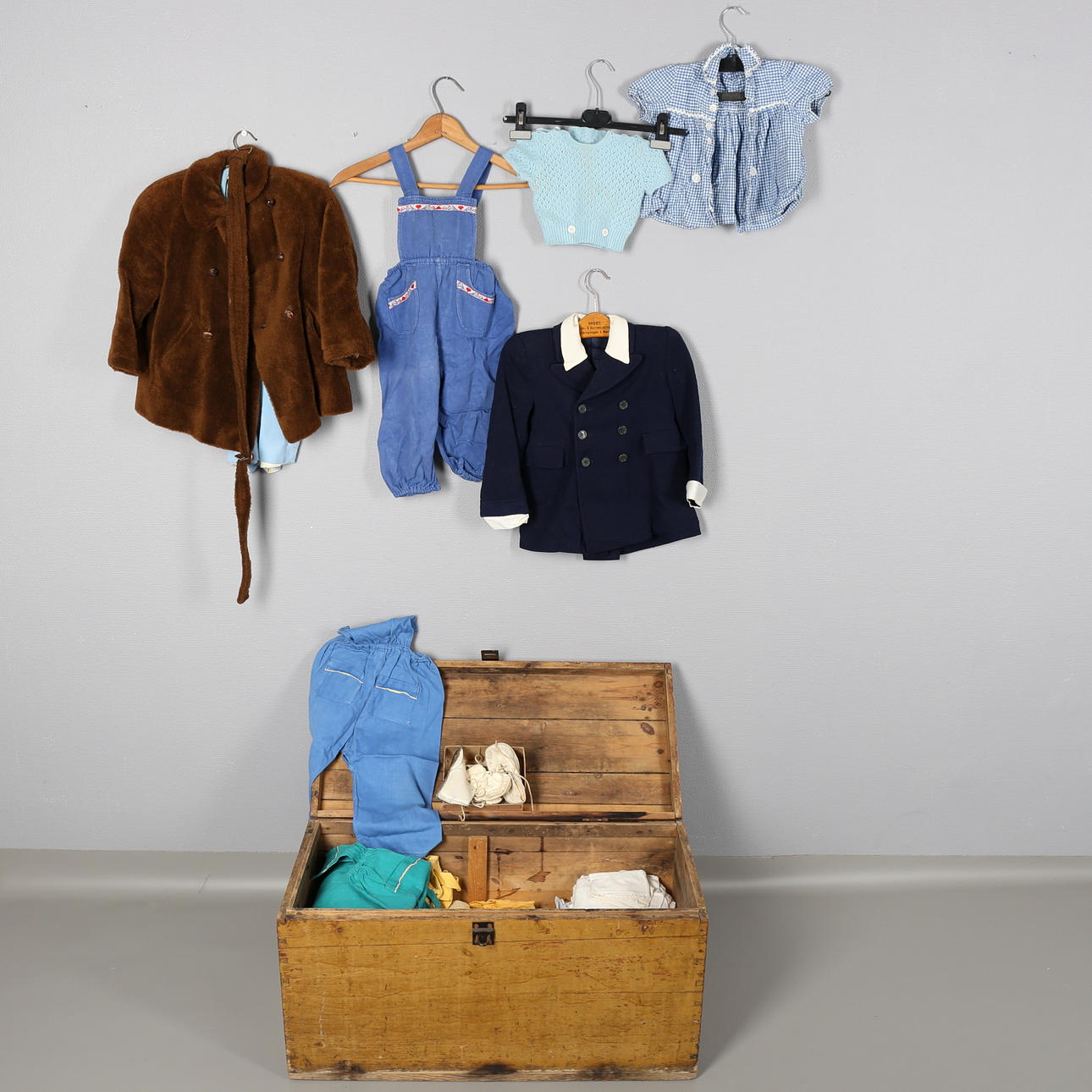 TRÄKISTA med barnkläder/skor. Ett femtiotal. 1951.