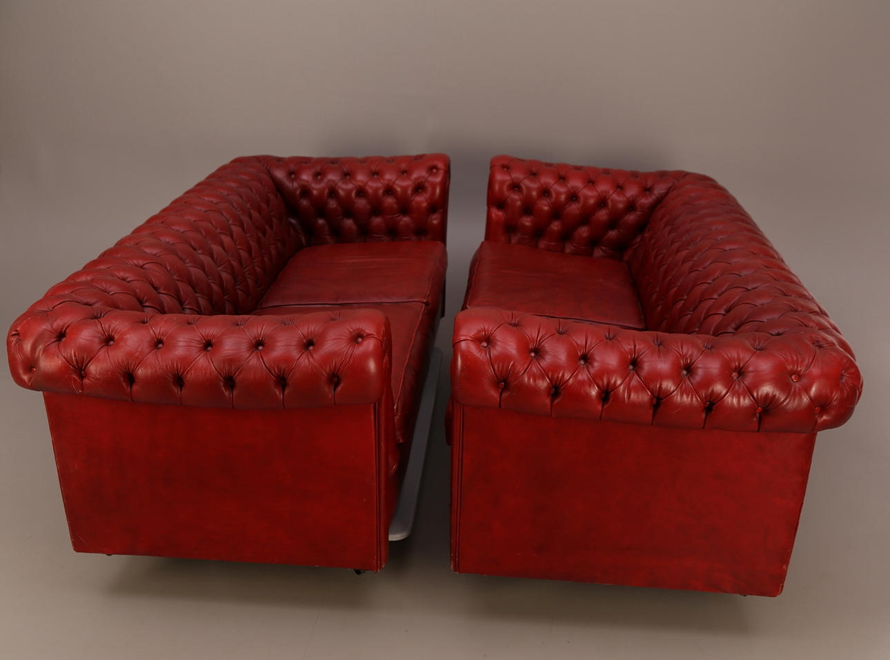 SOFFOR, ett par, Chesterfield, rött skinn, 1900-tal, med hjul, två sittkuddar.