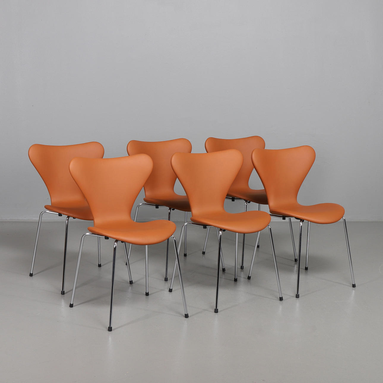 ARNE JACOBSEN. Sieben Stühle, 6 in Nussbaumleder Elegance.