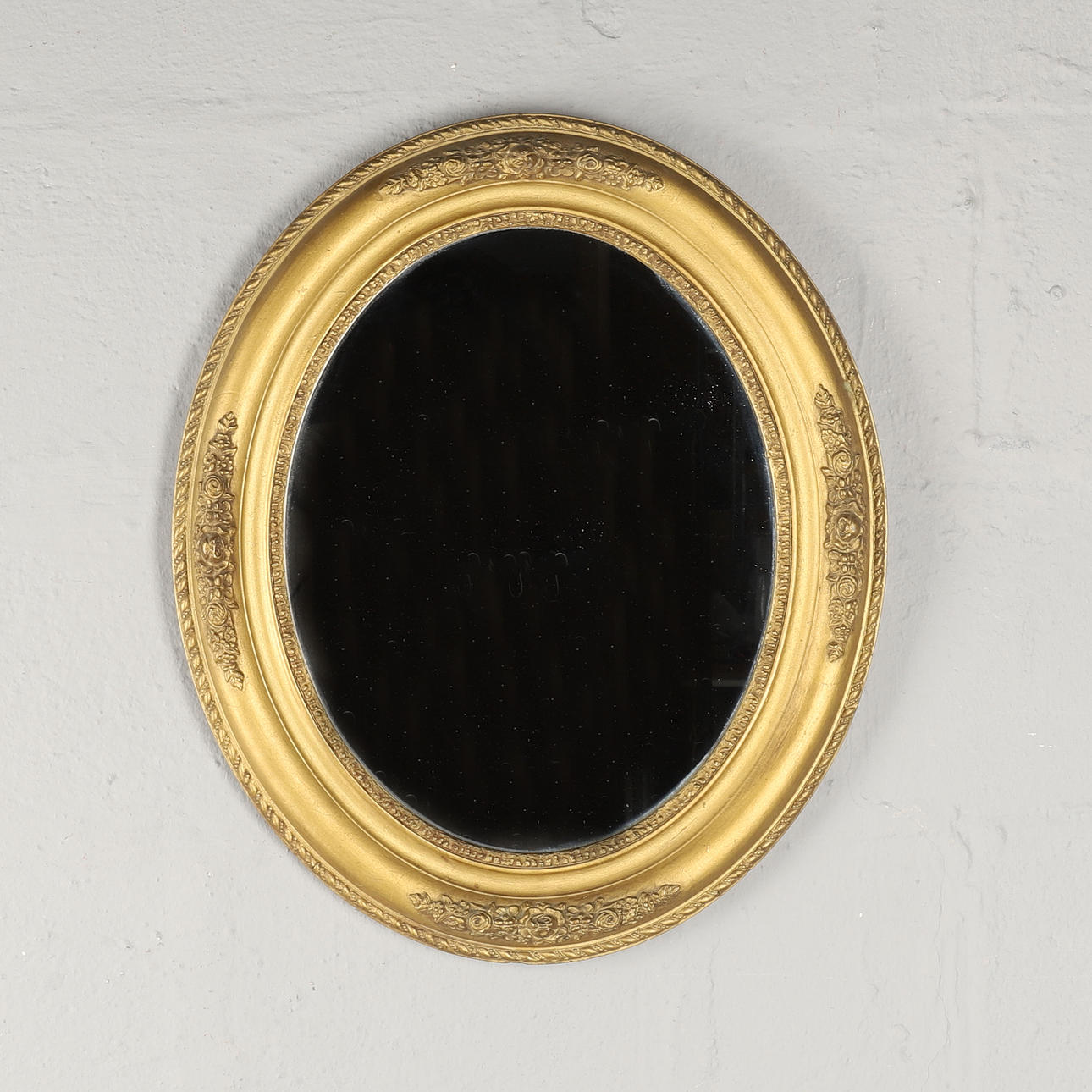 EN MODERN OVAL VÄGGSPEGEL.