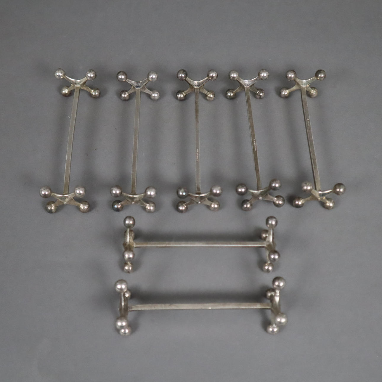 - 7 MESSERBÄNKCHEN - um 1900, Metall, versilbert.