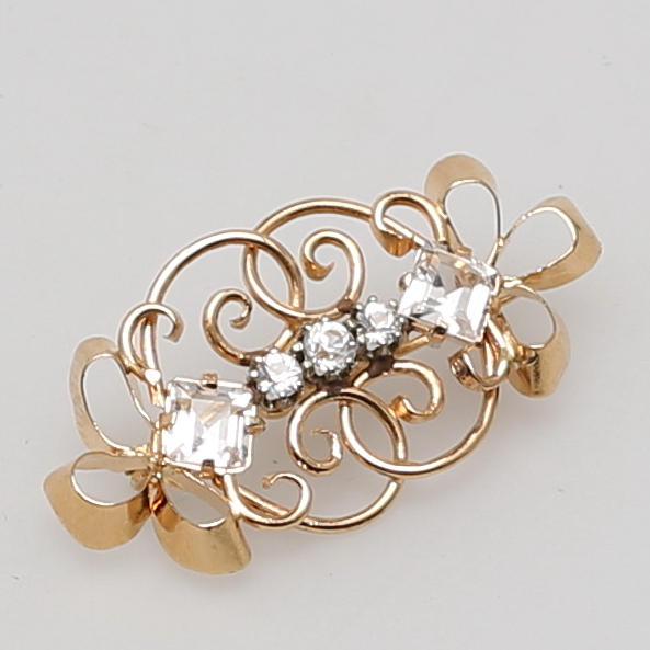 BROSCH i 18K gulguld besatt med stenar.