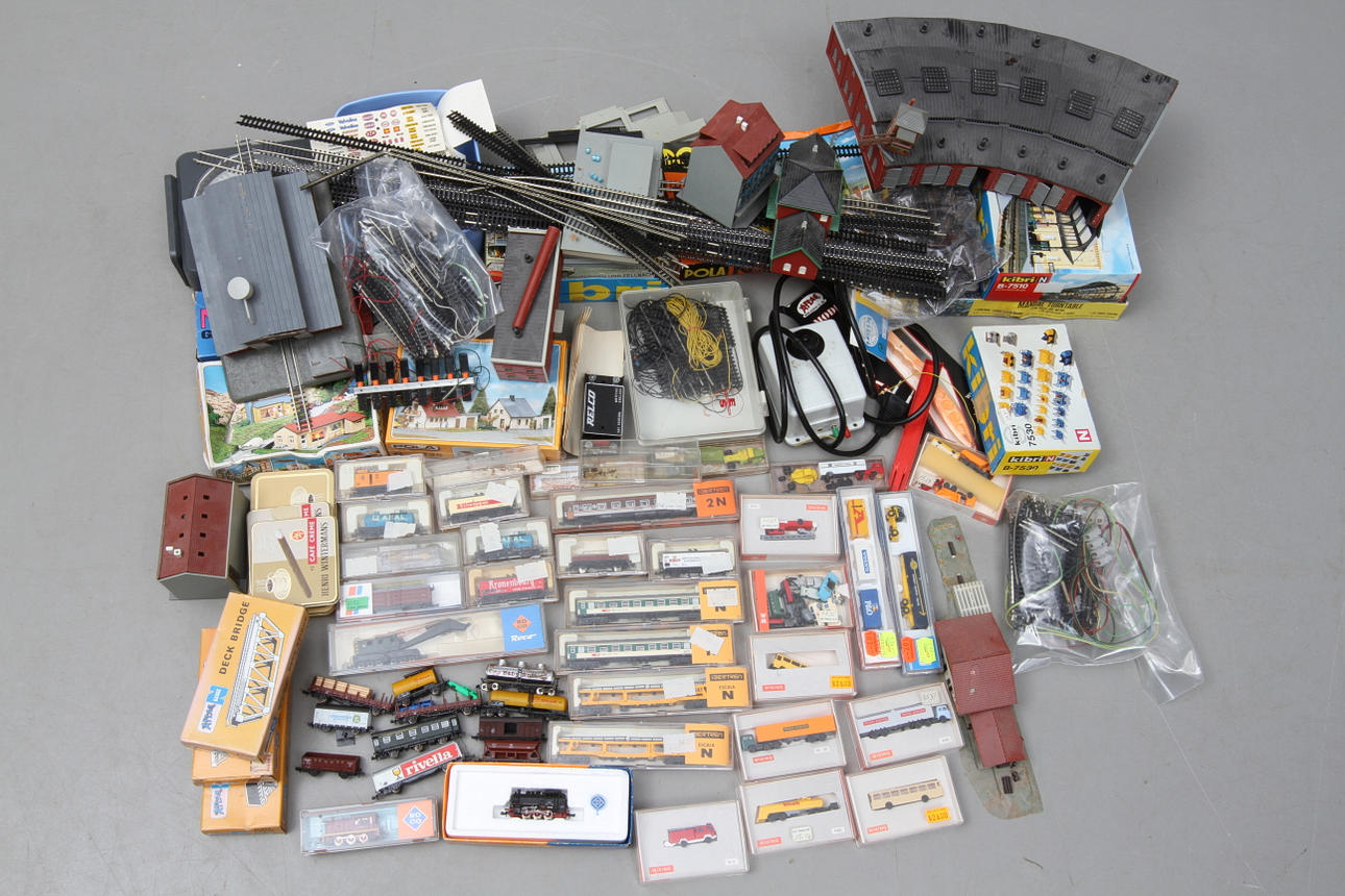 MODELLTÅG ROCO med flera skala N. 2 lådor. 2 lok, cirka 30 vagnar, räls, byggnader, bilar och tillbehör. Delvis originalkartonger.