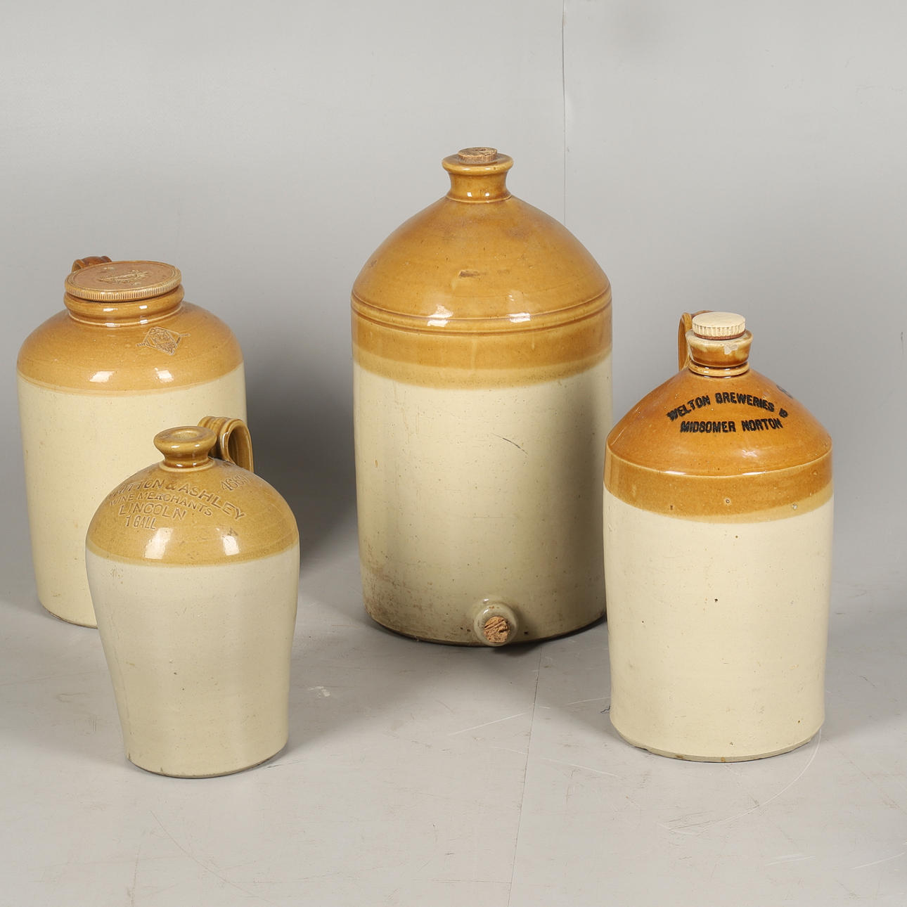 FOUR VINTAGE STONEWARE FLAGONS.