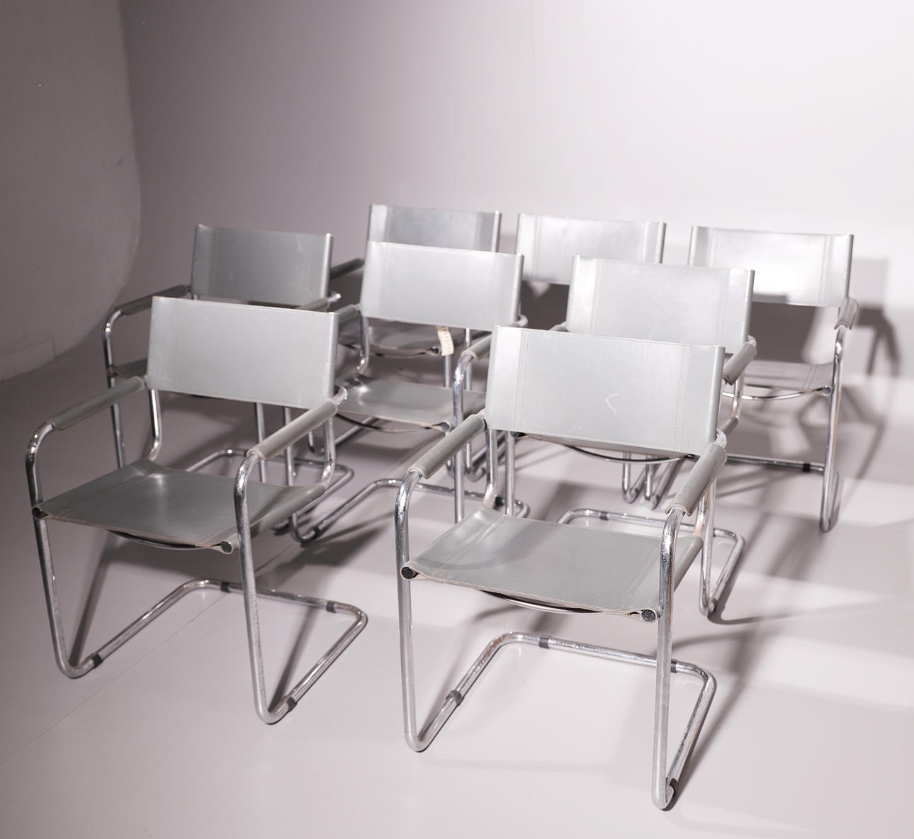 UPPSÄTTNING AV ÅTTA DESIGNER FÅTÖLJER. GRÅTT OCH KROM LÄDER.