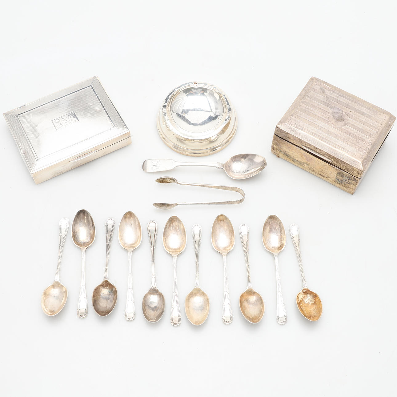 TWO SILVER CIGARETTE BOXES, ASHTRAY, TEASPOONS AND TONGS.