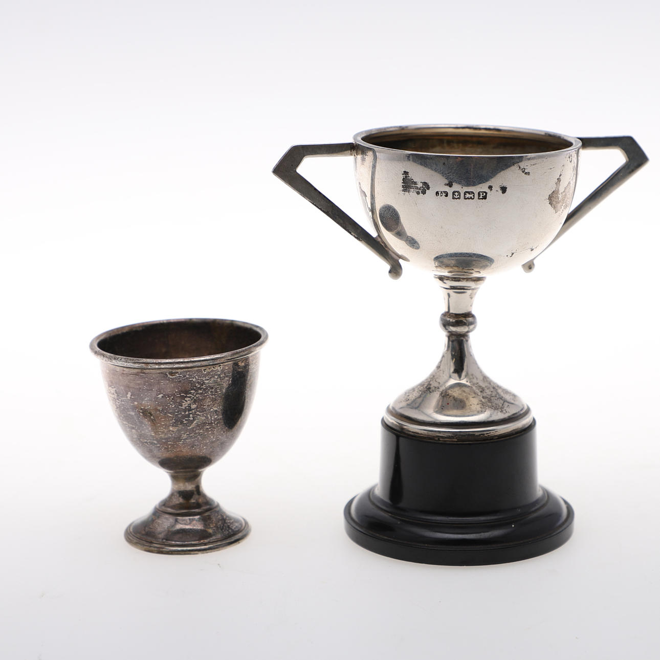 A SILVER TROPHY AND A SILVER PLATED EGG CUP.