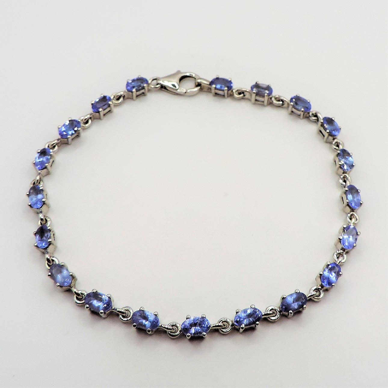 STERLING SILVER TANZANITE TENNIS BRACELET.