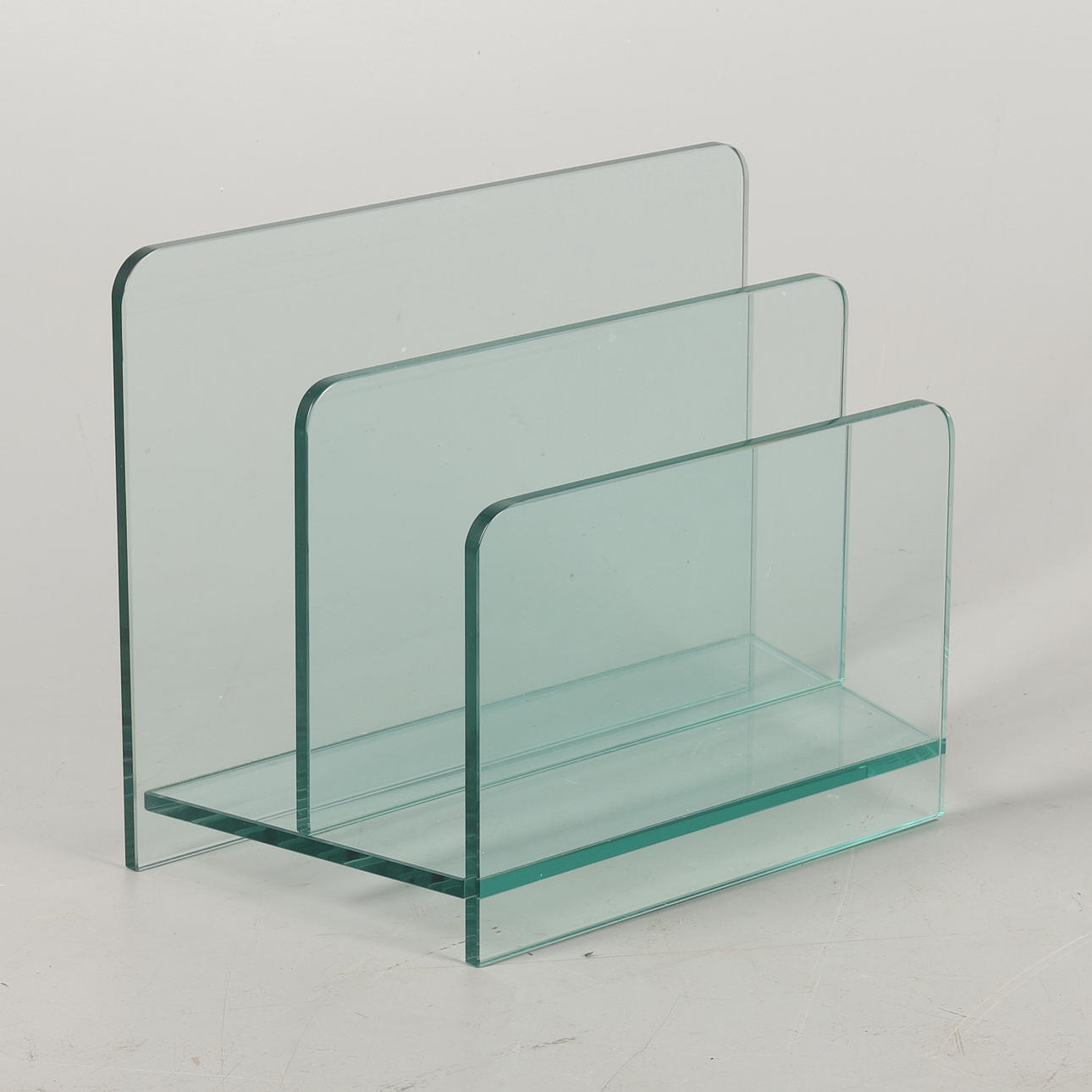 A VINTAGE GLASS TWO-TIER MAGAZINE RACK.