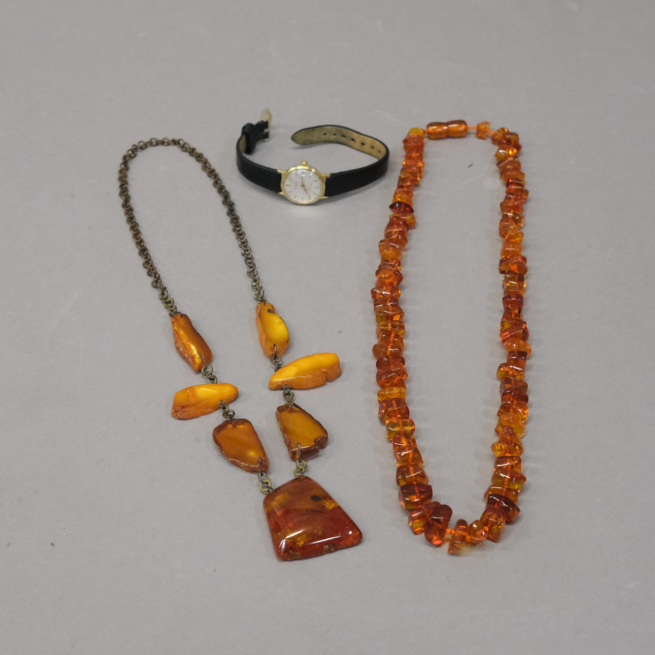 BRACELET WATCH AND TWO AMBER NECKLACE.