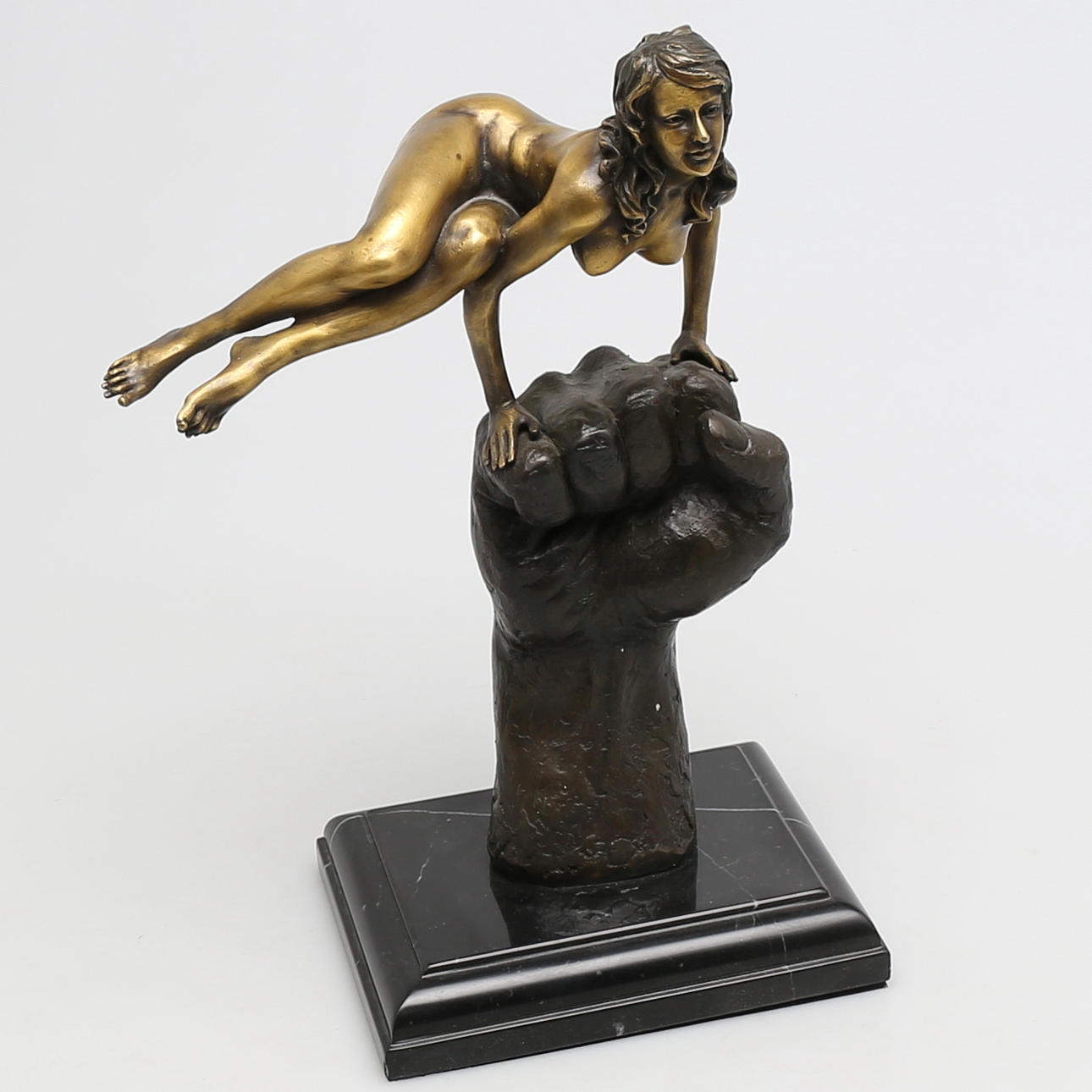 OKÄND KONSTNÄR. Kvinna balanserar på knuten hand i brons. Osignerad.