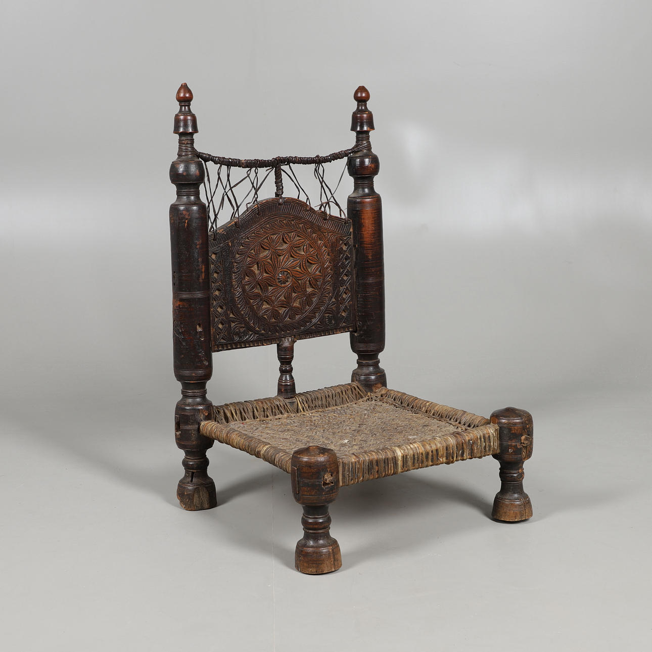 AN AFGHAN LOW SEAT CHAIR.