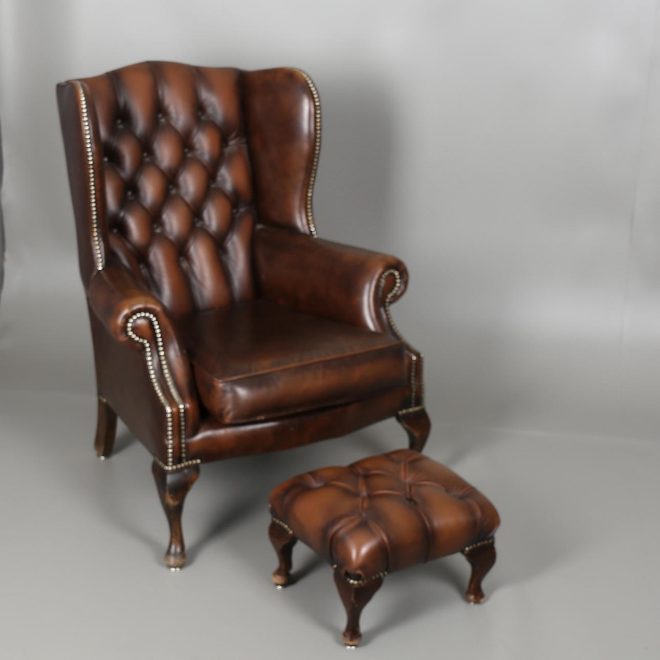 ÖRONLAPPSFÅTÖLJ med FOTPALL, klädsel i brunt skinn, On Reflection, 1900-talets andra hälft.