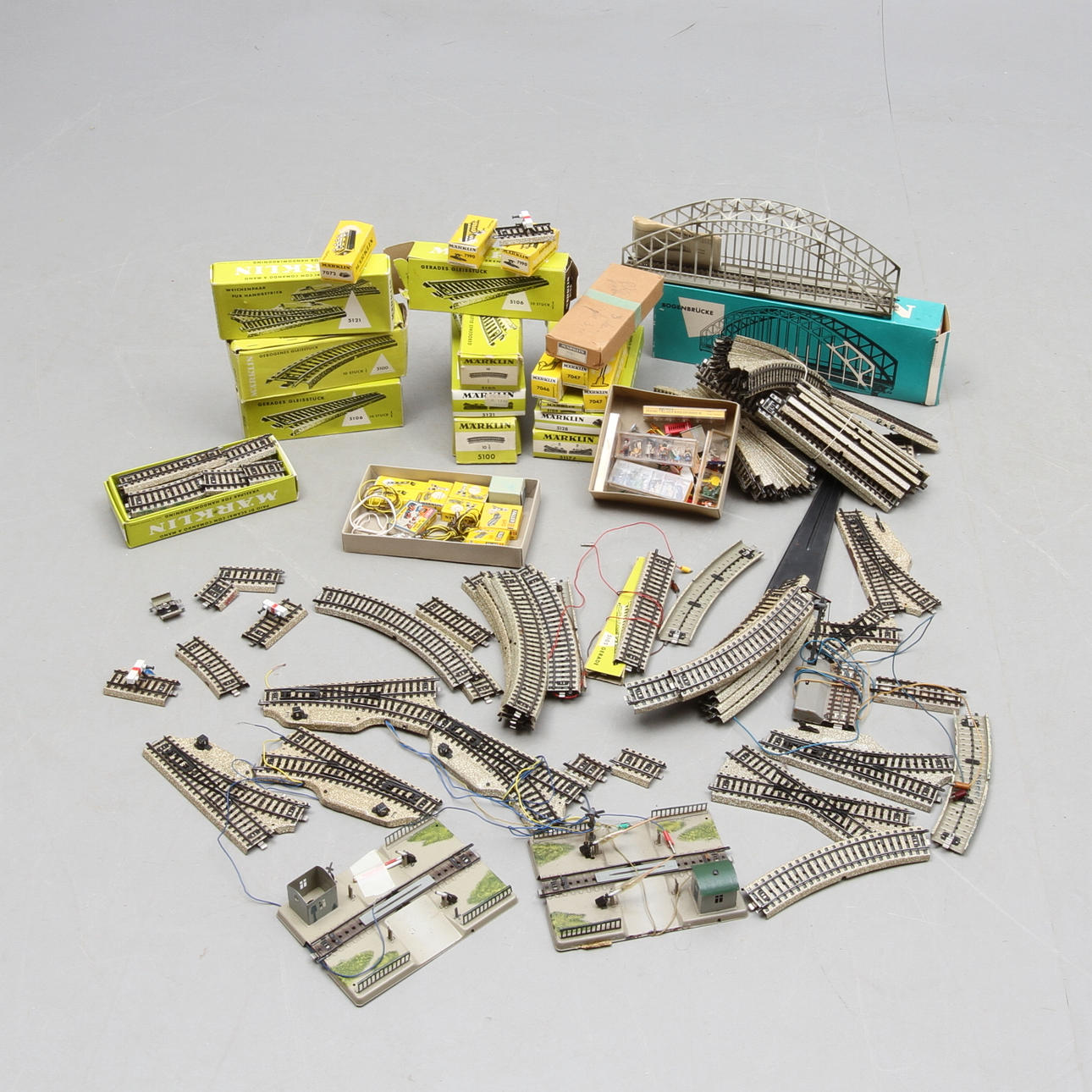 MÄRKLIN räls, växlar, broar och tillbehör. Delvis originalkartonger.