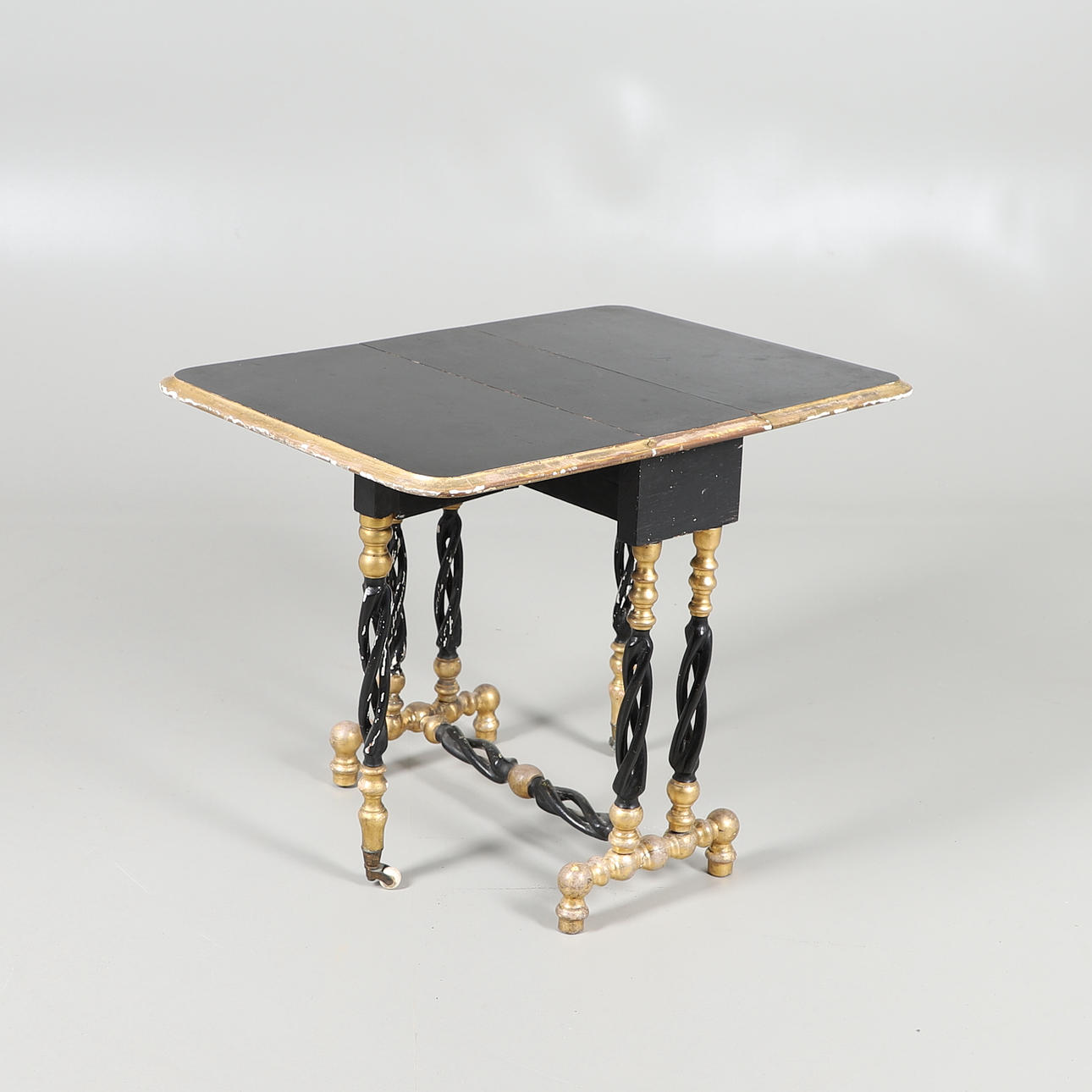 AN EBONISED AND GILT SUTHERLAND TABLE.
