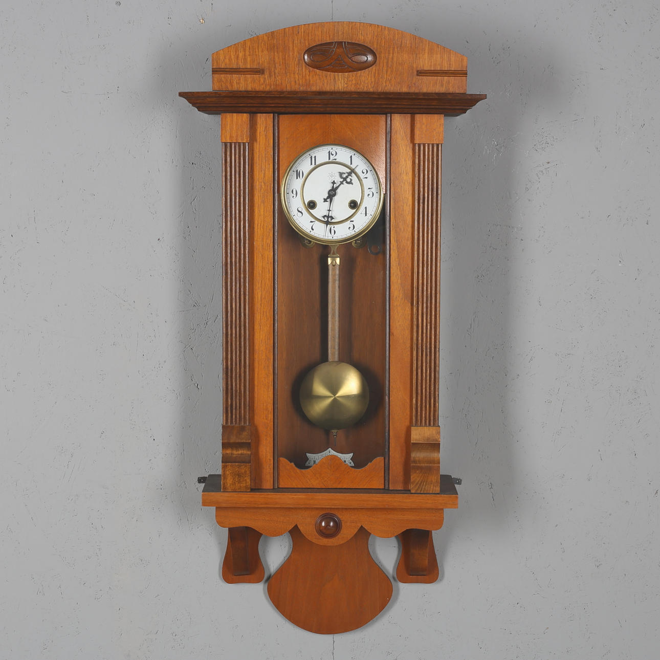 WALL CLOCK, wooden case, removable crest, Junghans, early 20th century. Pendulum included.