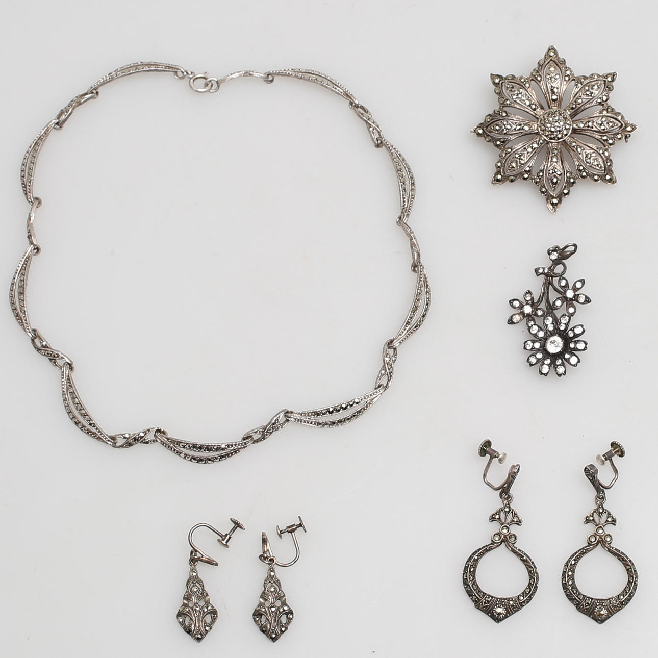 PARTI SMYCKEN i silver, maraksiter, glas, 7 delar, 1900-talets första hälft.