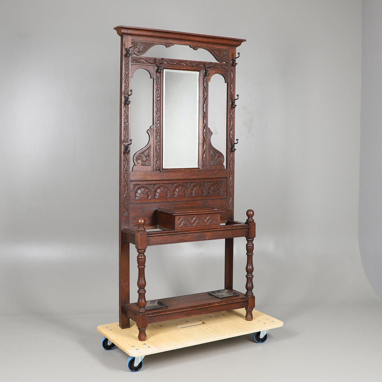 A CARVED OAK MIRROR BACK HALL STAND.