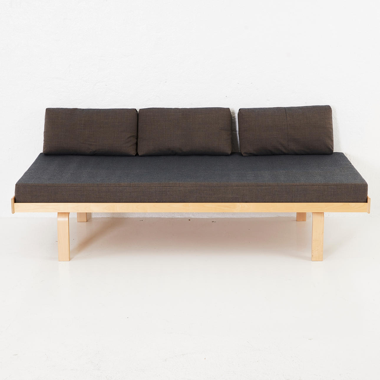 ALVAR AALTO. Daybed 710 for Artek, solid and layer-glued birch, textile-covered mattress with three pillows, frame labeled "Artek 801935-2015", mattress cover "Artek".