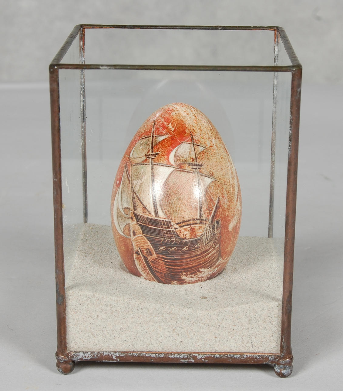 MARIA LANCING. Skillinge, Ristat ägg med farygsmotiv i glasmonter.