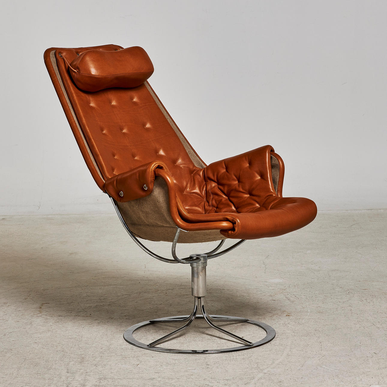 BRUNO MATHSSON, "Jetson", lænestol, DUX, model formgivet 1969, forkromede ben med drejefunktion, betræk og nakkestøtte i brunt læder, mærkemærket.