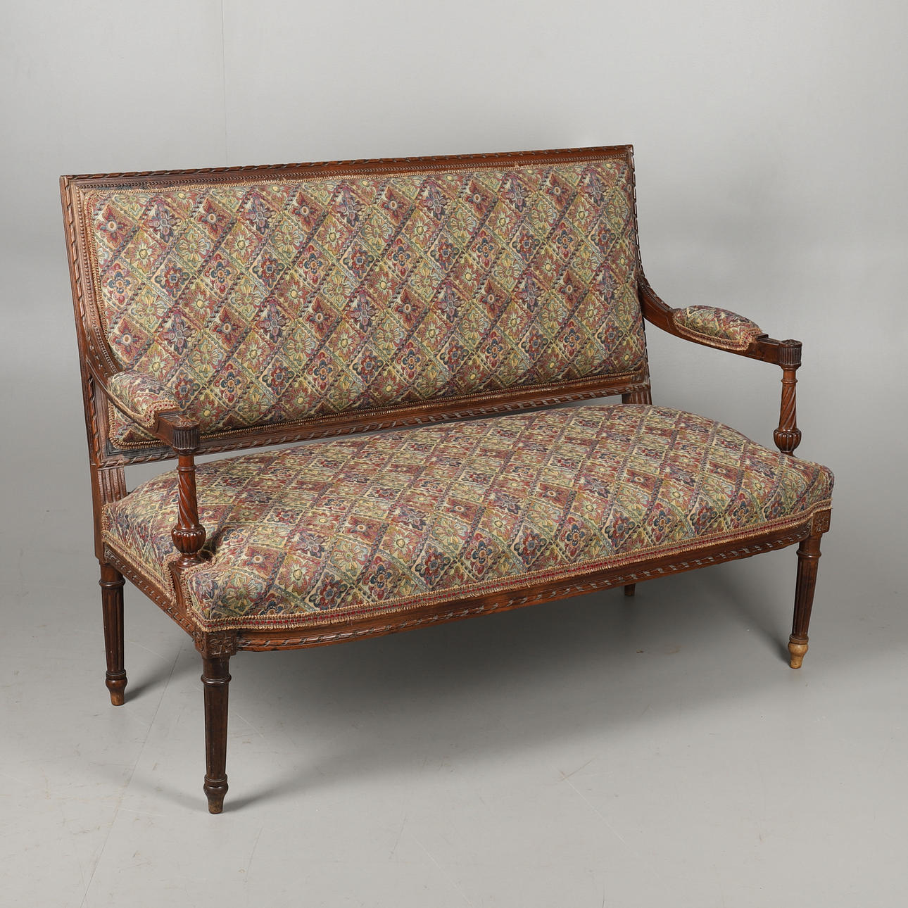 A VICTORIAN CARVED WALNUT SETTEE.