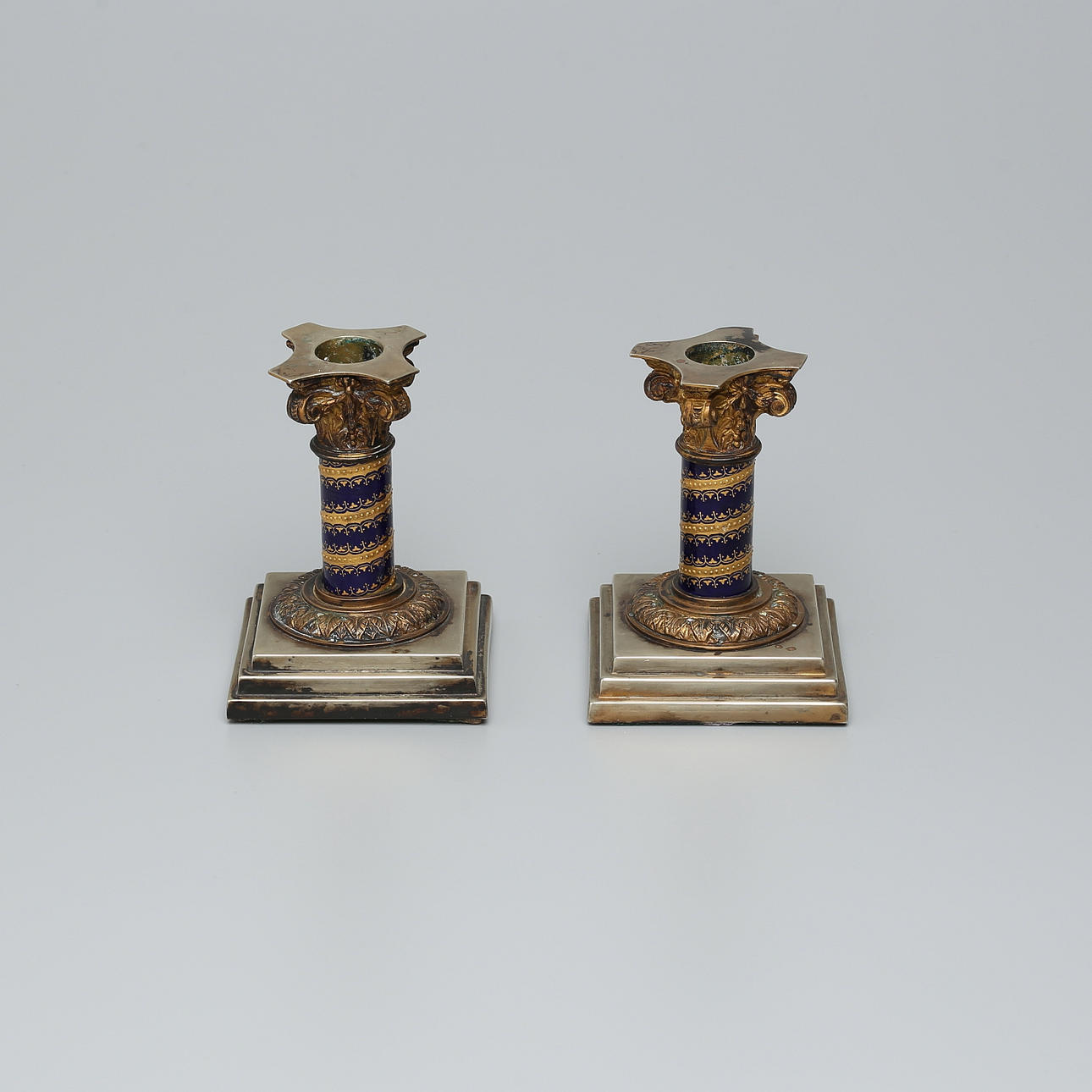 CANDLESTICKS, 1 pair, Column-shaped, square foot, decorated capitals.