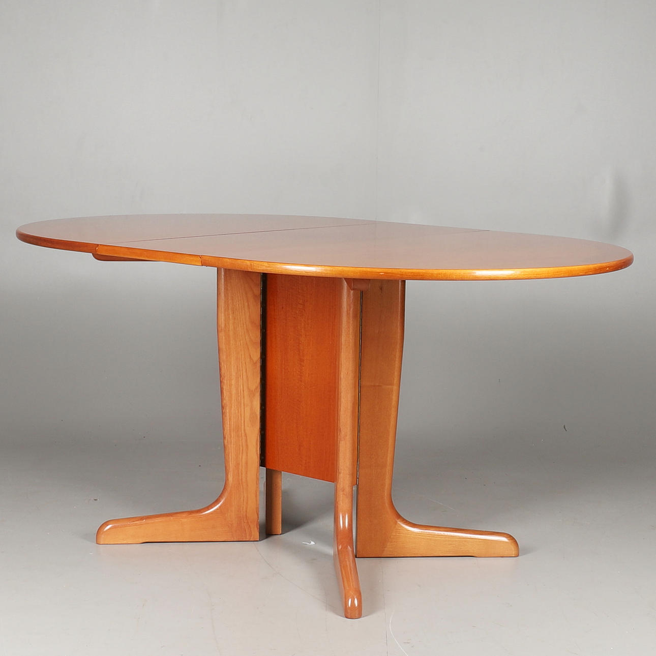 A G-PLAN TEAK DROP LEAF DINING TABLE.