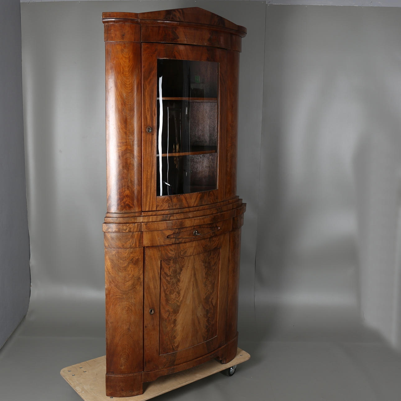 HÖRNSKÅP i mahognyfaner, senempire, 1800-tal.