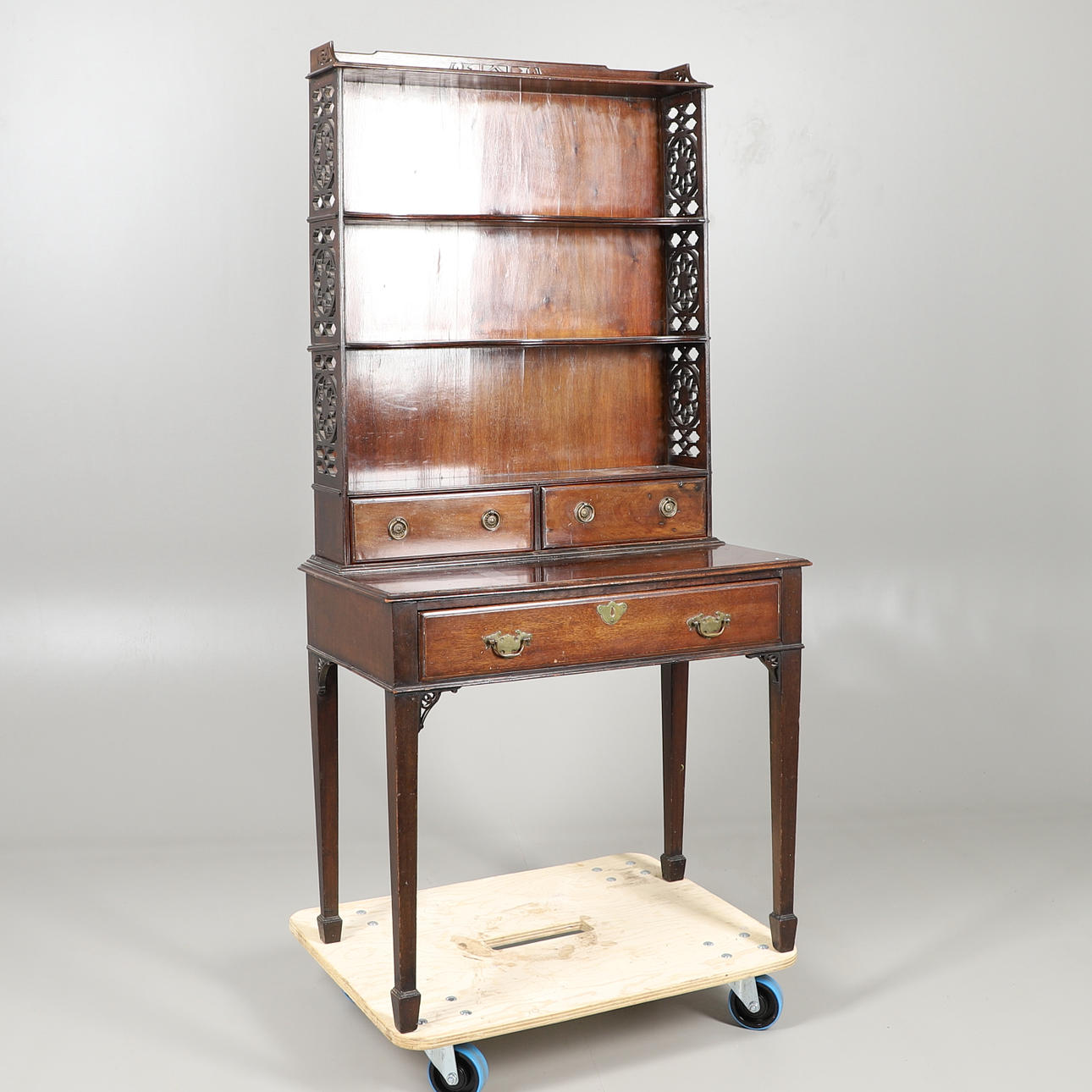 A MAHOGANY TABLE WITH FRETTED DISPLAY SHELVES.